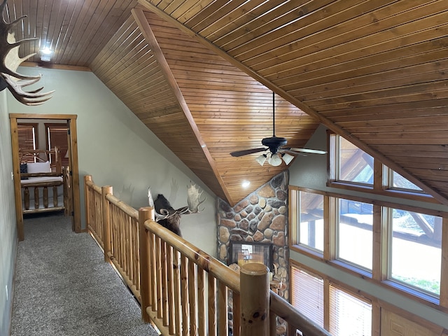 hall with wooden ceiling, vaulted ceiling, and dark carpet