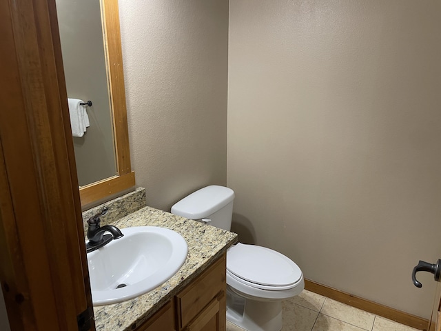 bathroom with tile patterned flooring, vanity, and toilet