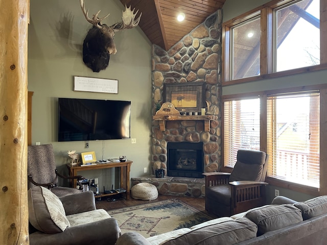 living room with a stone fireplace, wooden ceiling, and a healthy amount of sunlight