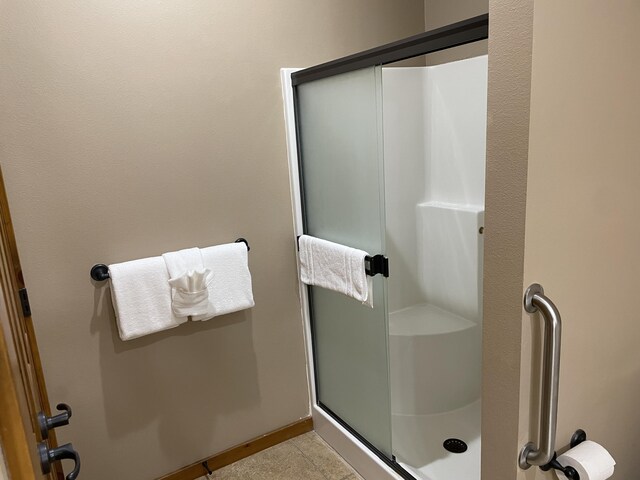 bathroom with tile patterned floors and a shower with door