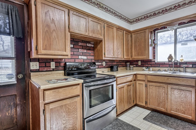 kitchen with tasteful backsplash, stainless steel electric stove, and sink