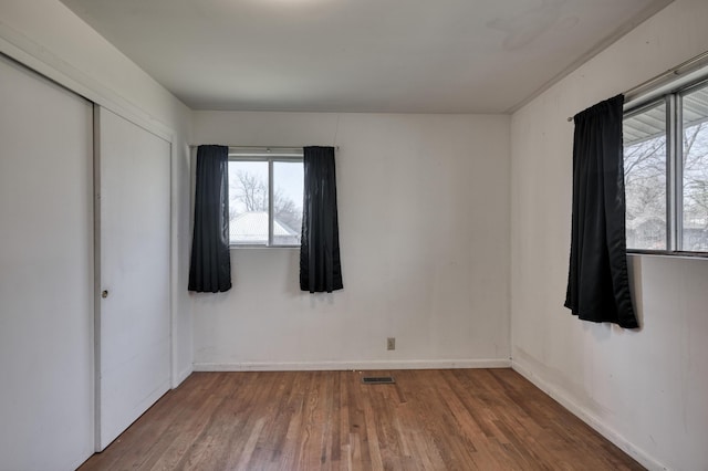 unfurnished bedroom with hardwood / wood-style flooring and a closet