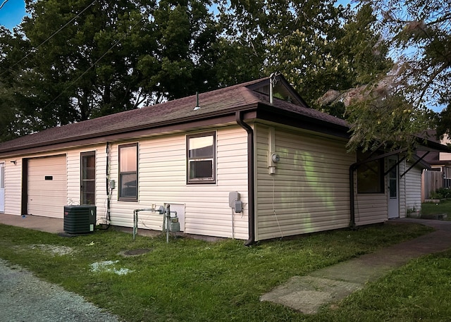 view of home's exterior featuring a yard, cooling unit, and a garage