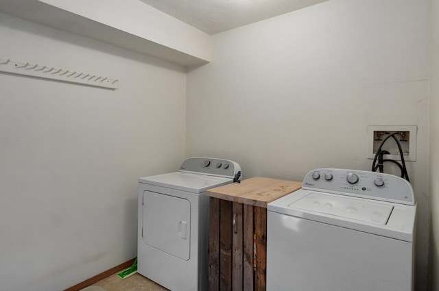 laundry area with a textured ceiling and washer and clothes dryer