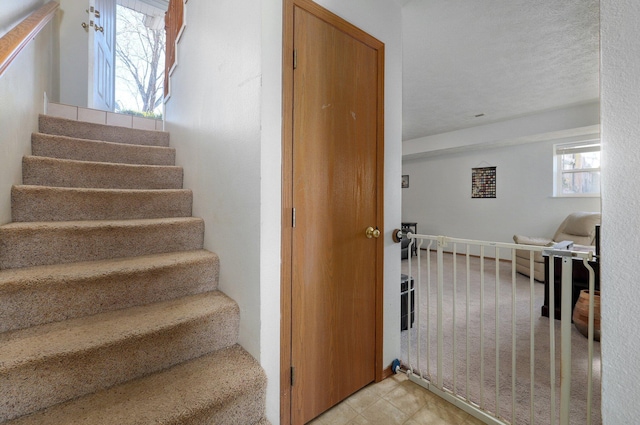 stairway featuring a textured ceiling