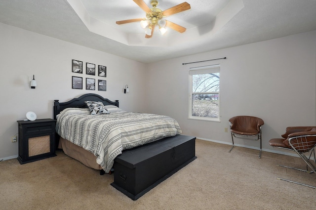 carpeted bedroom featuring a raised ceiling, ceiling fan, and a textured ceiling