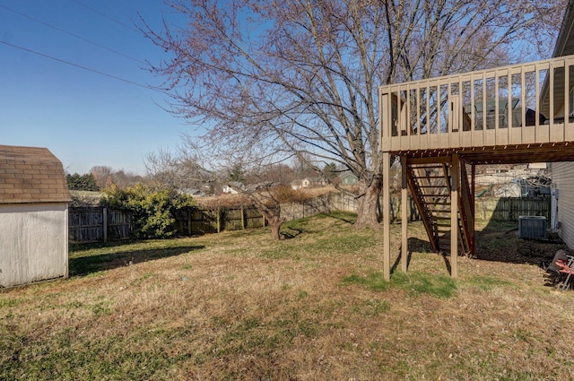 view of yard with central air condition unit and a wooden deck