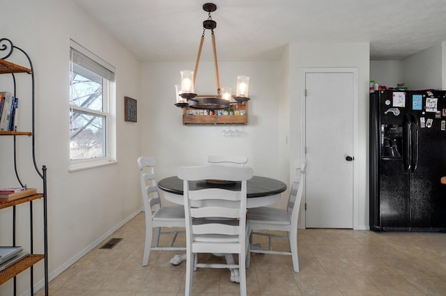 dining room featuring light tile patterned flooring and an inviting chandelier