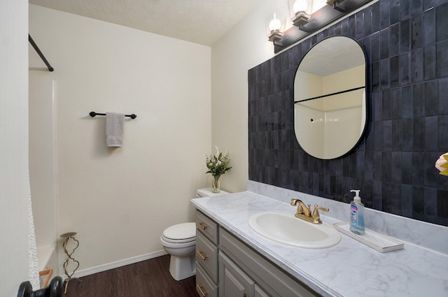 bathroom with a shower, hardwood / wood-style floors, a textured ceiling, toilet, and vanity