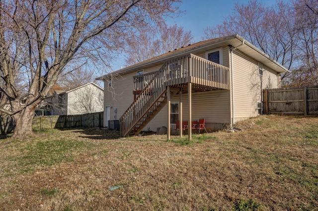 rear view of house featuring a wooden deck and a yard