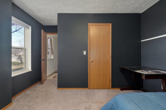 bedroom featuring light carpet and a textured ceiling