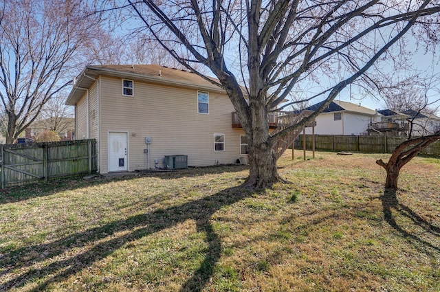 rear view of house with a lawn and central AC