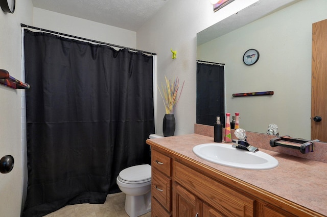 bathroom featuring vanity, a textured ceiling, and toilet