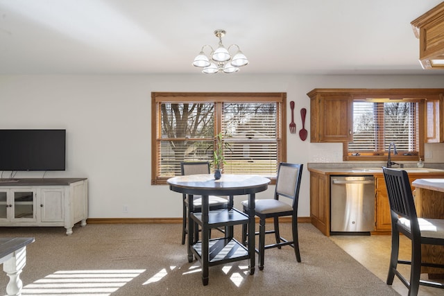 dining space featuring light colored carpet, a healthy amount of sunlight, and a notable chandelier