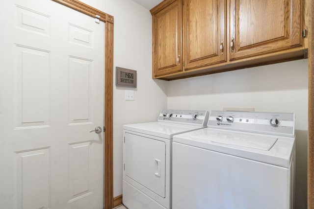 laundry area featuring washer and clothes dryer and cabinets