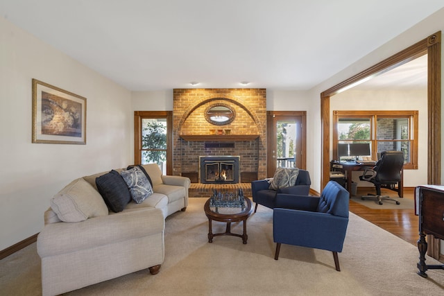 living room featuring a brick fireplace and light wood-type flooring