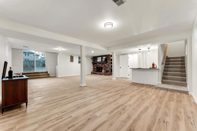 below grade area with stairs, light wood-style flooring, and visible vents