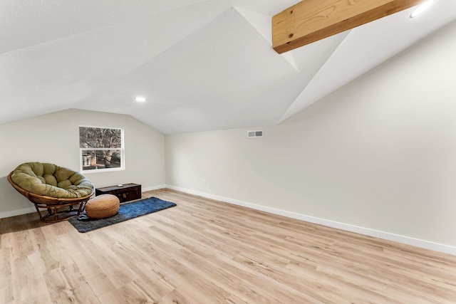 sitting room featuring visible vents, lofted ceiling, light wood-type flooring, and baseboards