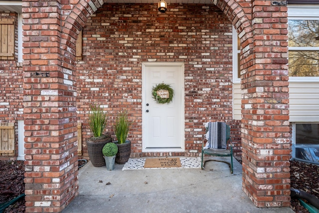 doorway to property featuring brick siding