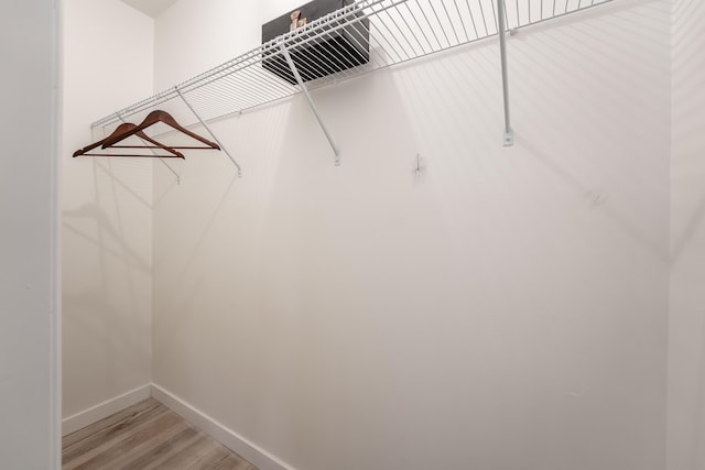 walk in closet with light wood-style floors