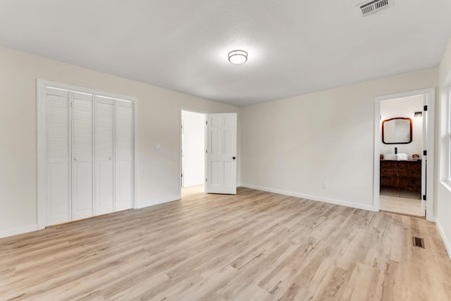 unfurnished bedroom featuring baseboards, visible vents, and light wood-type flooring