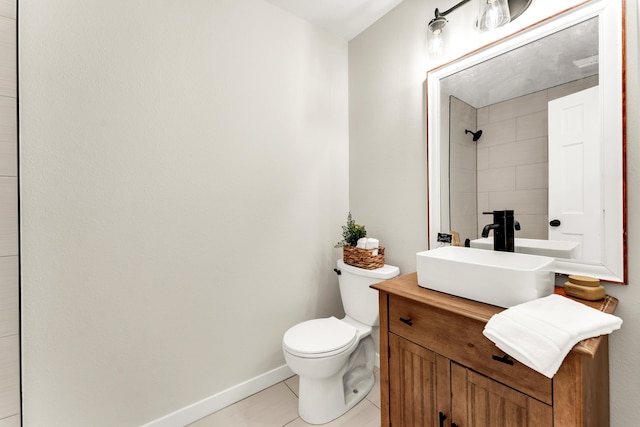 bathroom featuring baseboards, toilet, a tile shower, tile patterned floors, and vanity