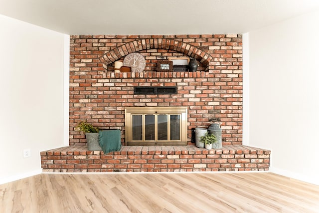 details with a fireplace, wood finished floors, and baseboards