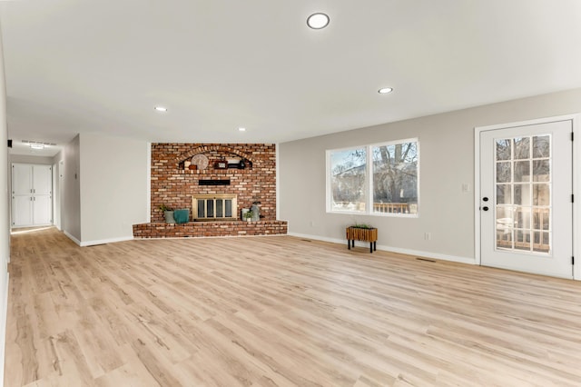 unfurnished living room featuring recessed lighting, baseboards, light wood-style flooring, and a fireplace