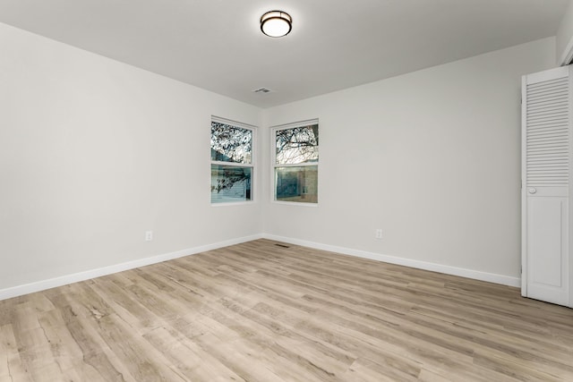 spare room with visible vents, baseboards, and light wood-style floors