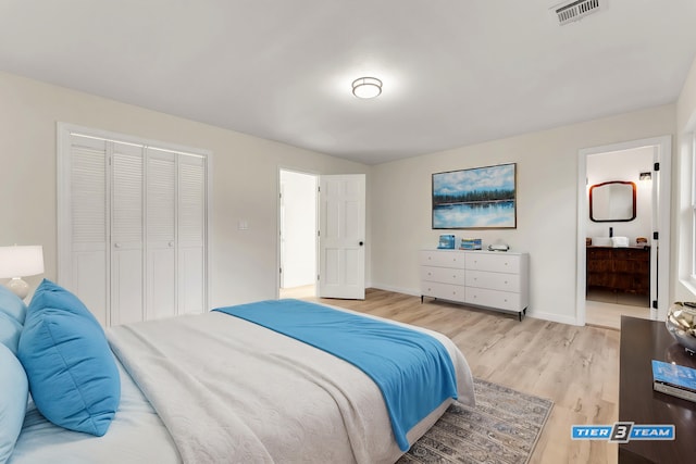 bedroom with visible vents, ensuite bathroom, a closet, light wood finished floors, and baseboards