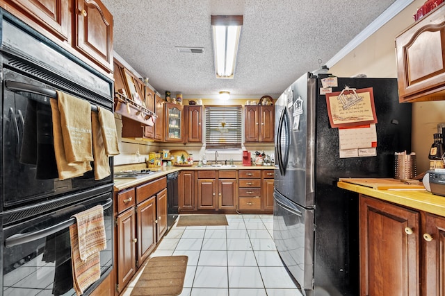 kitchen featuring sink, crown molding, a textured ceiling, light tile patterned floors, and black appliances