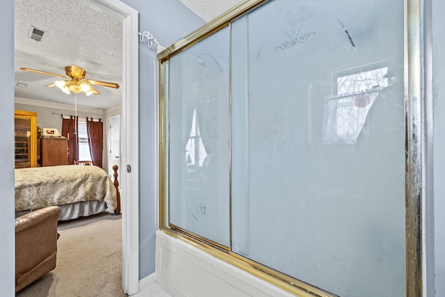 bathroom with ceiling fan, ornamental molding, shower / bath combination with glass door, and a textured ceiling