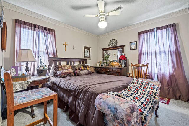 carpeted bedroom with multiple windows, ceiling fan, and a textured ceiling