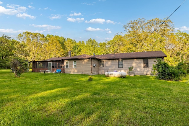 back of house featuring a sunroom and a lawn