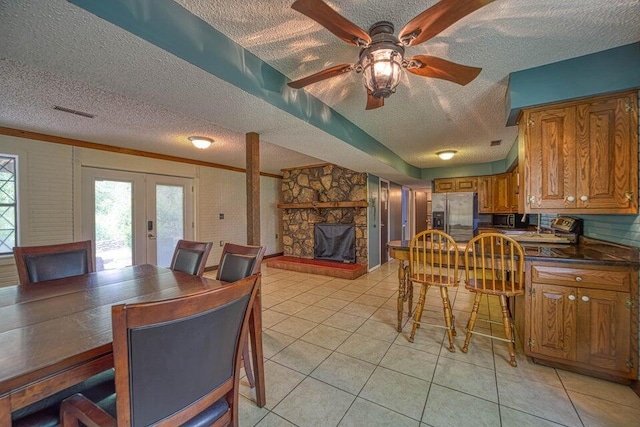 tiled dining area with french doors and a textured ceiling