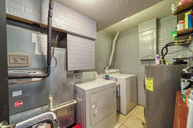 clothes washing area with electric water heater, independent washer and dryer, a textured ceiling, light tile patterned floors, and heating unit