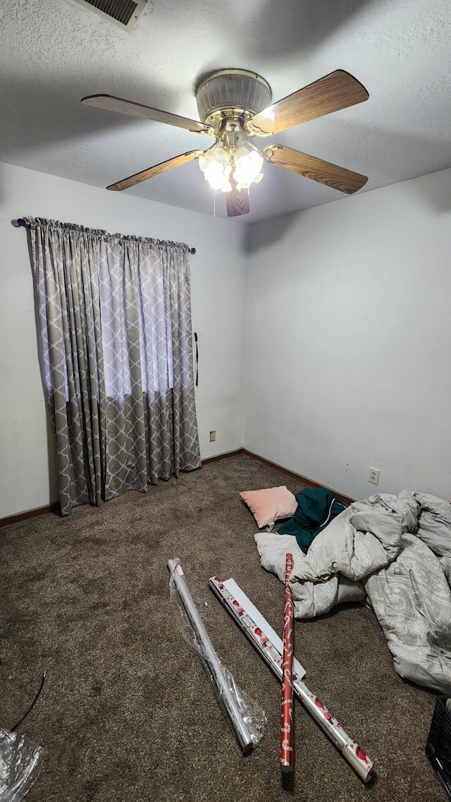 interior space with ceiling fan, carpet, and a textured ceiling