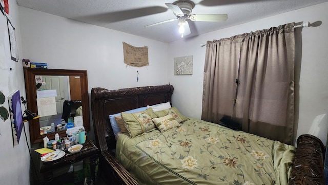 bedroom with ceiling fan and a textured ceiling