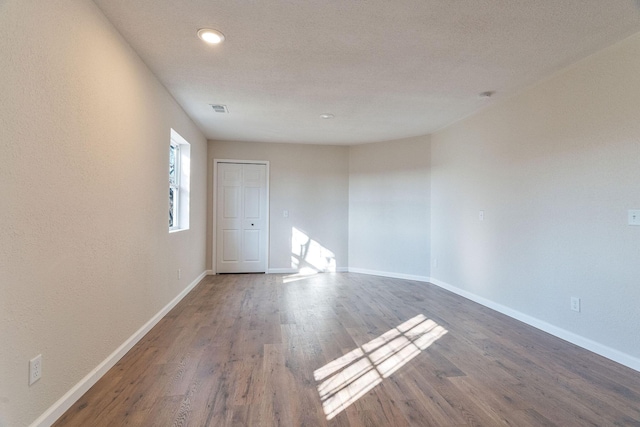 empty room with dark hardwood / wood-style flooring