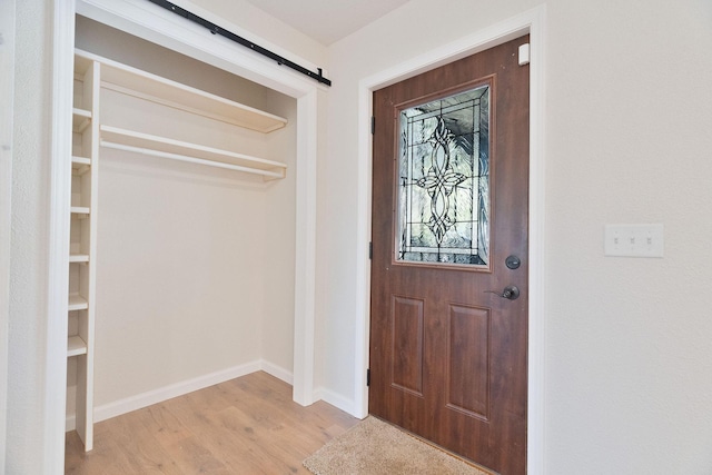 entrance foyer with a barn door and light hardwood / wood-style flooring