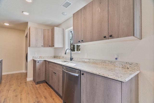 kitchen featuring sink, dishwasher, light stone counters, and light wood-type flooring