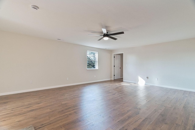 spare room with ceiling fan and dark wood-type flooring