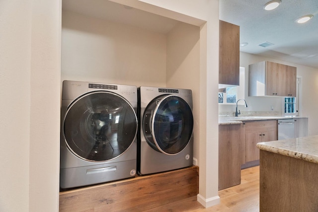 laundry room featuring light hardwood / wood-style floors, separate washer and dryer, and sink