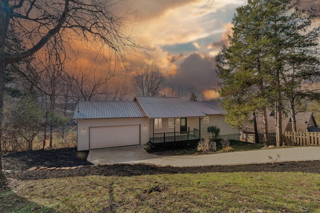 view of front of property with a porch, a garage, and a lawn