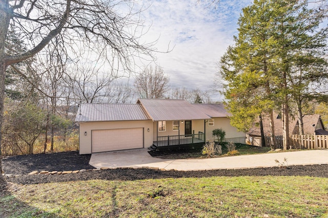 ranch-style house featuring covered porch, a garage, and a front yard