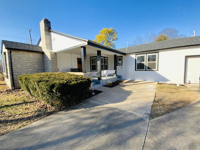 ranch-style house with covered porch and a garage