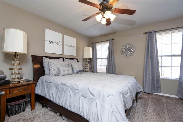 bedroom featuring carpet, ceiling fan, and multiple windows