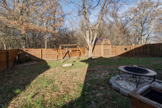 view of yard featuring a fire pit and a storage unit