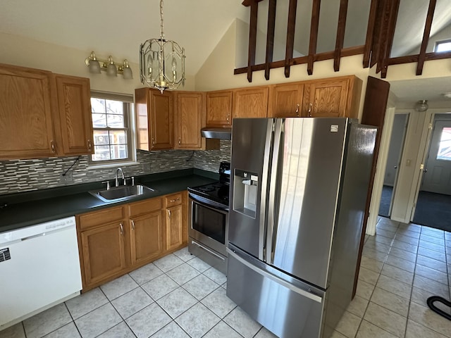 kitchen featuring sink, light tile patterned floors, stainless steel appliances, and decorative light fixtures