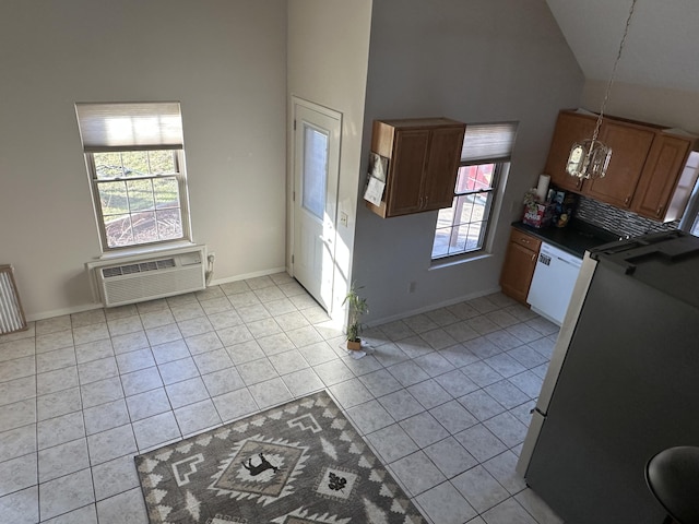 kitchen with white dishwasher, light tile patterned flooring, high vaulted ceiling, and a chandelier